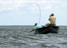 Two anglers in a boat on on a windy lake with rough waves