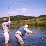 Landing a 17-inch smallmouth bass caught using a strike indicator