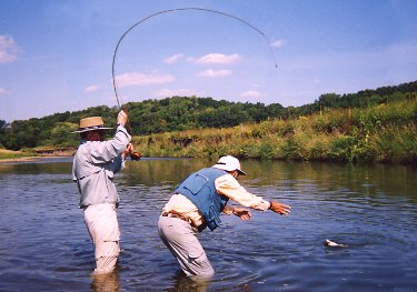 Landing a 17-inch smallmouth bass caught using a strike indicator